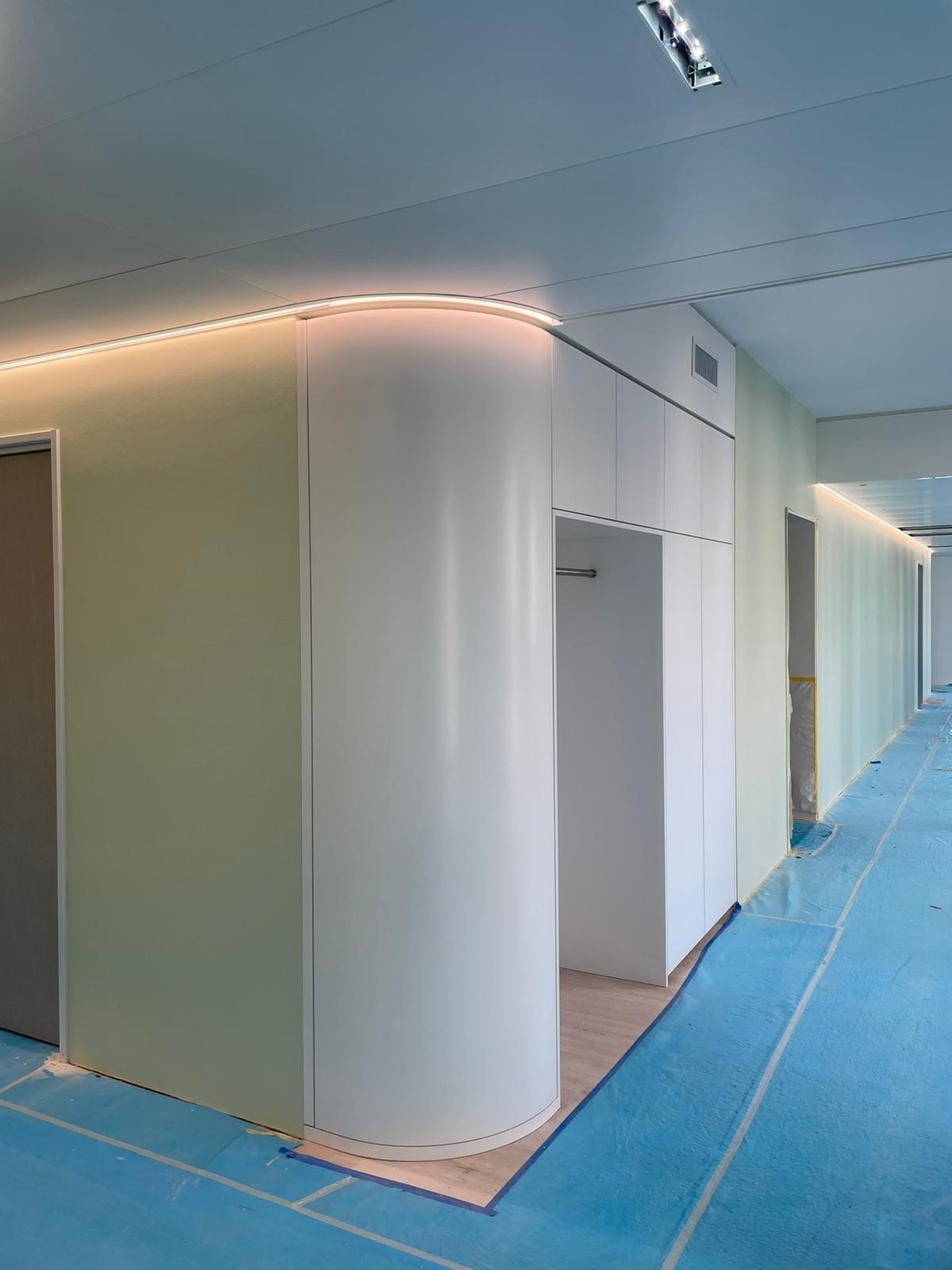 Geschwungene Trockenbauwand und Decke mit indirekter Beleuchtung